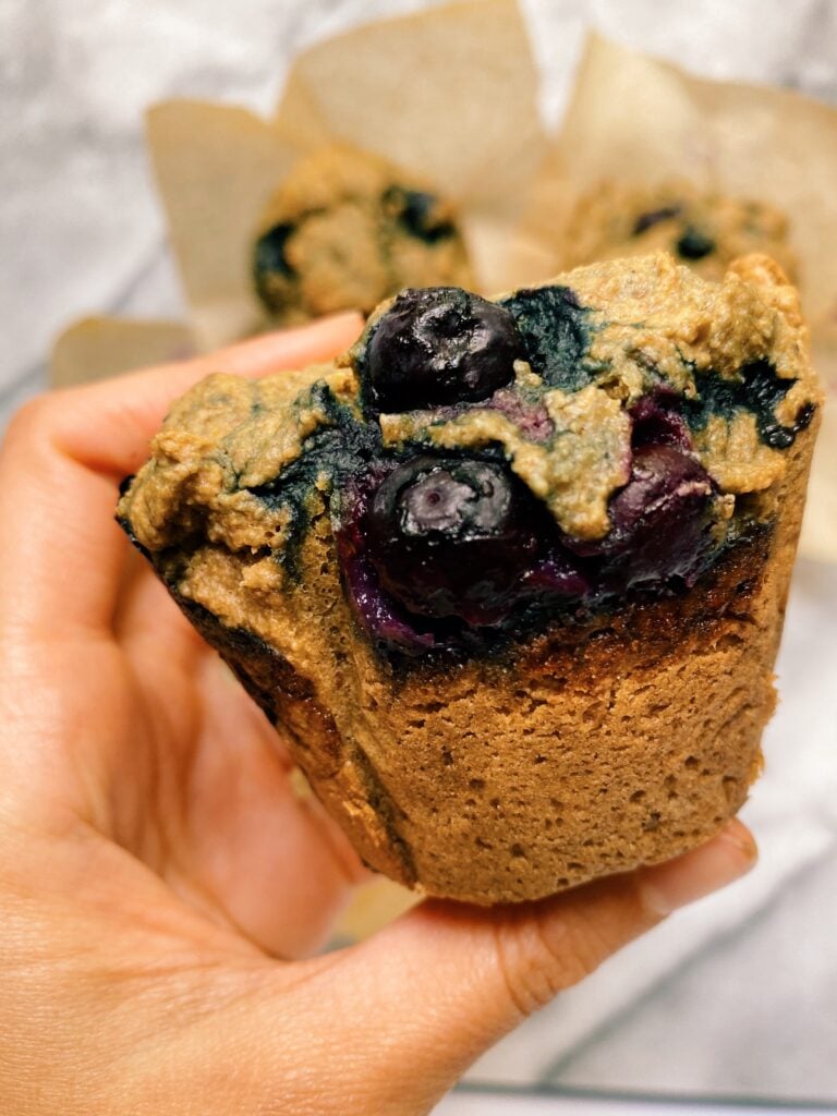 hand holding blueberry muffins